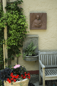 St. Matthew pulpit tile by William Daley hanging on the patio wall in our garden.