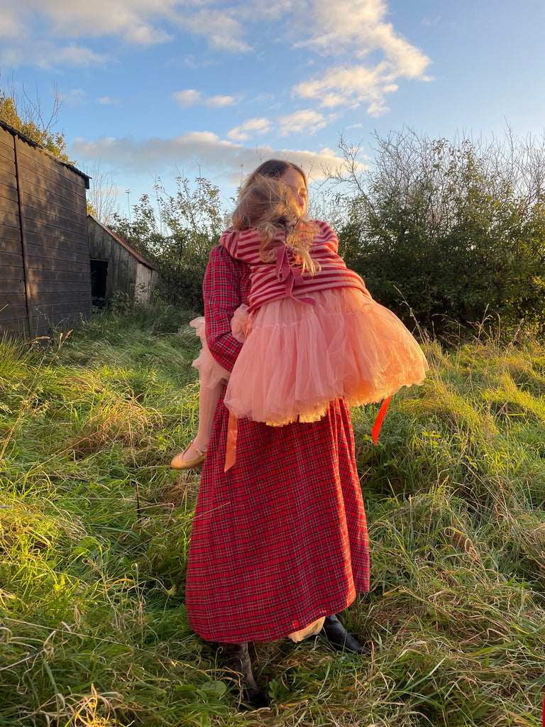 Haley wears the Dilly dress in red tartan holding her daughter Virginia