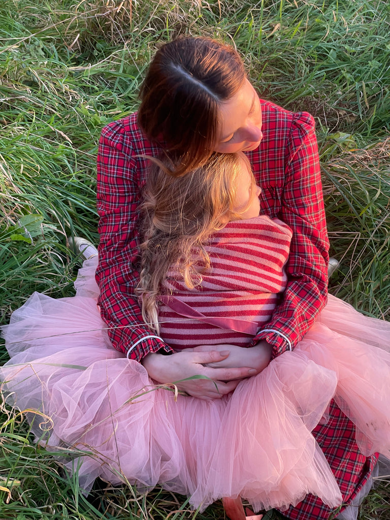 Haley holds her daughter wearing the Winnifred sweater in red and pink stripe