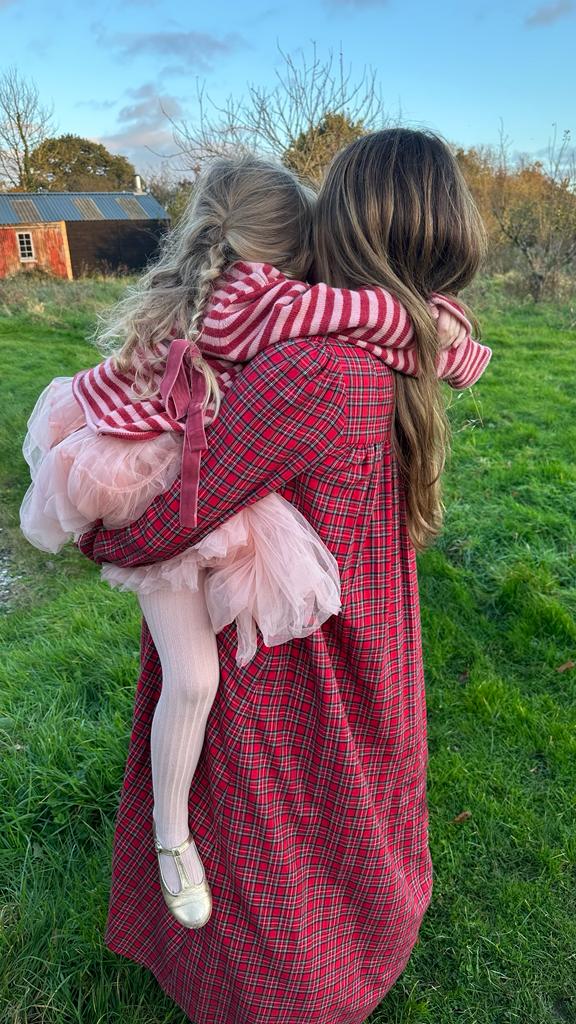 Haley wearing the Dilly dress in red tartan and Virigina wears the Winnifred sweater with her pink net skirt