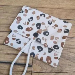 Pochette à savon double compartiment en coton enduit au motif léopard. Cette pochette dispose d'une petite cordelette en coton blanc lui permettant d'être suspendue dans la douche.
