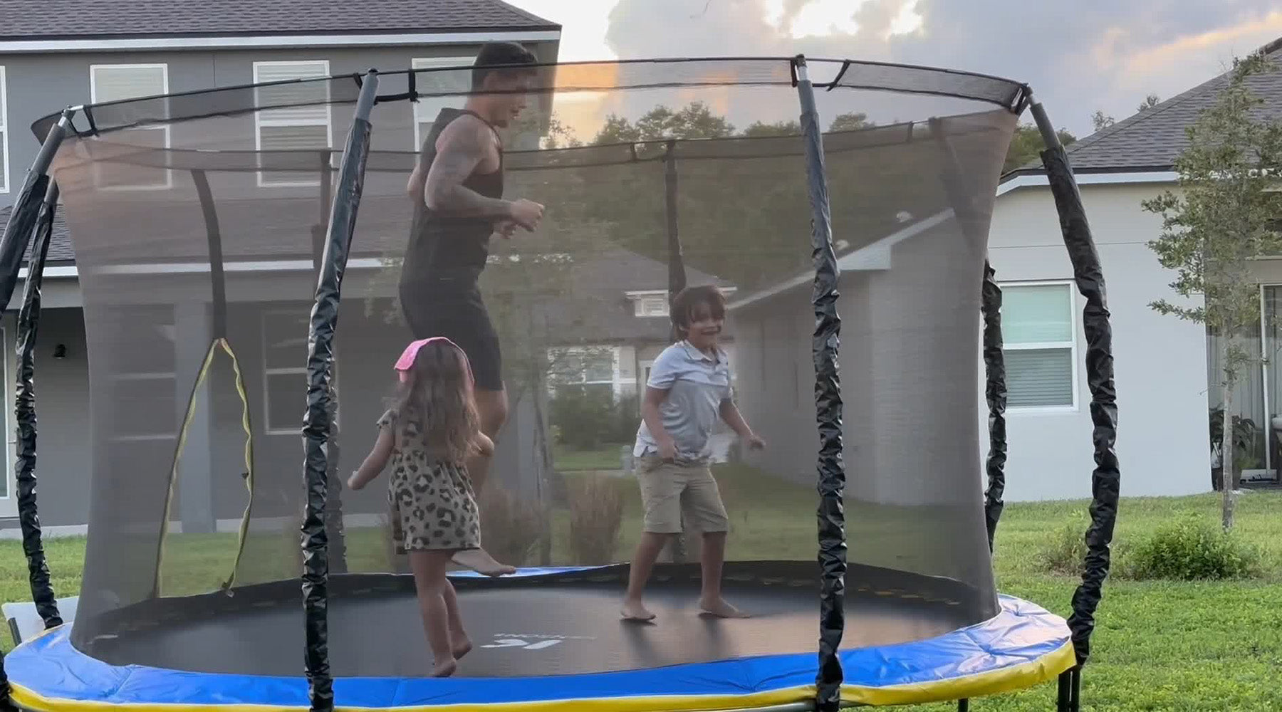 due bambini che giocano sul trampolino con il papà