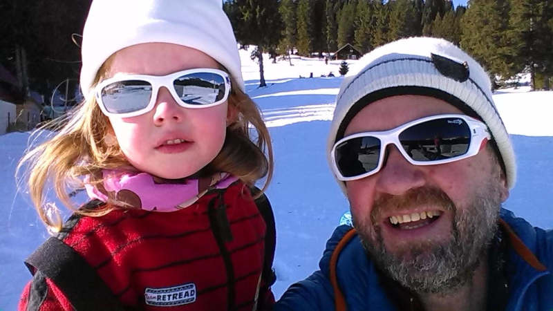 papà e bambino indossano occhiali sportivi durante escursione in montagna