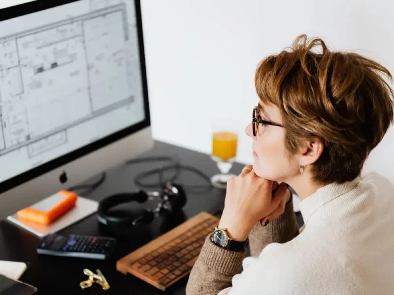 Woman Reading Information on Computer Monitor
