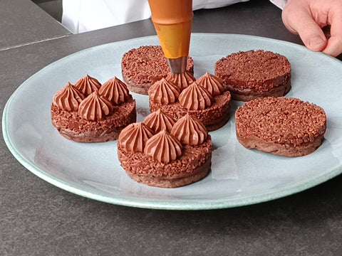 Pochage d’une ganache avec une douille PF14 sur un petit gâteau