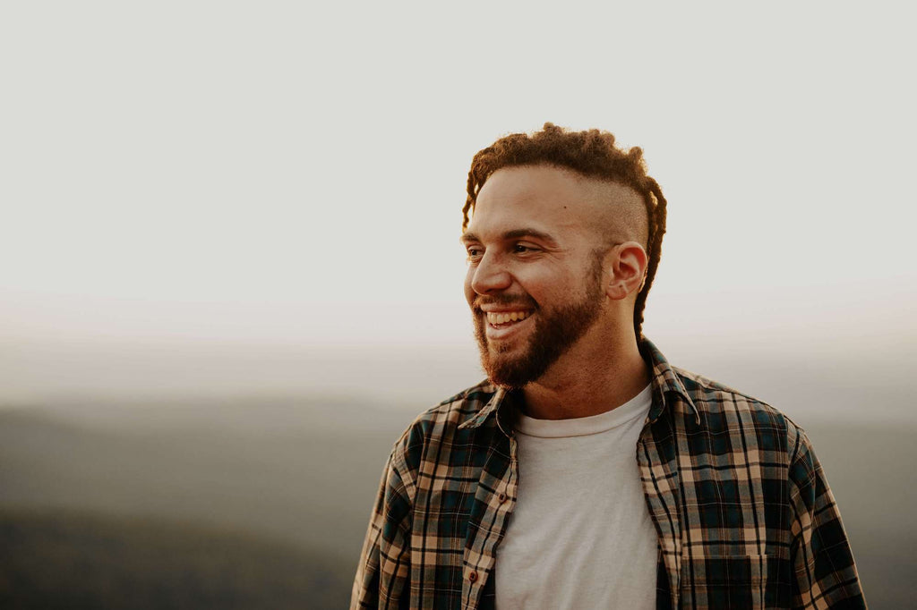man in flannel looking off in the distance at fall scenery