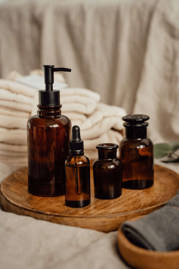 skincare bottles on round wooden tray