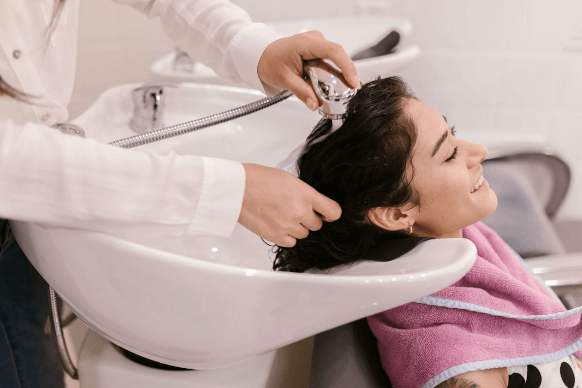 woman getting hair washed at salon sink