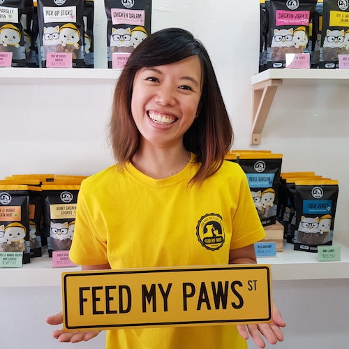 Holding a Feed My Paws street sign in Toa Payoh Outlet, Singapore