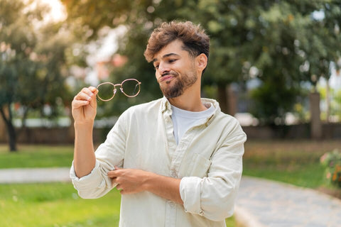 jovem em dúvida olhando óculos