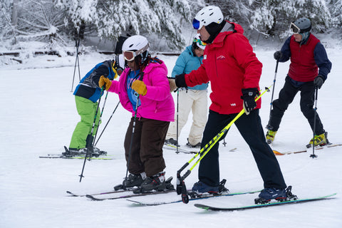 Image of an adult and child skiing side by side.