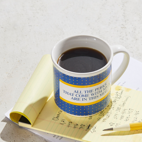 Mug of coffee on top of a yellow legal pad.