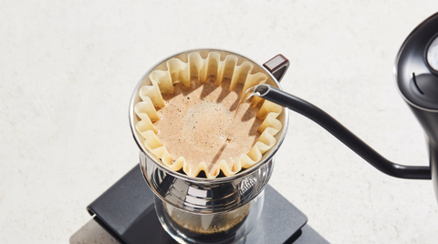 Water being poured over grounds in a Kalita Wave brewer on top of a scale.