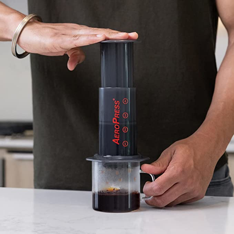 Person using an aeropress to make coffee.