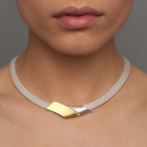 Model wears Elegant Manu bi-metal wraparound necklace at desingyard contemporary jewellery gallery dublin ireland