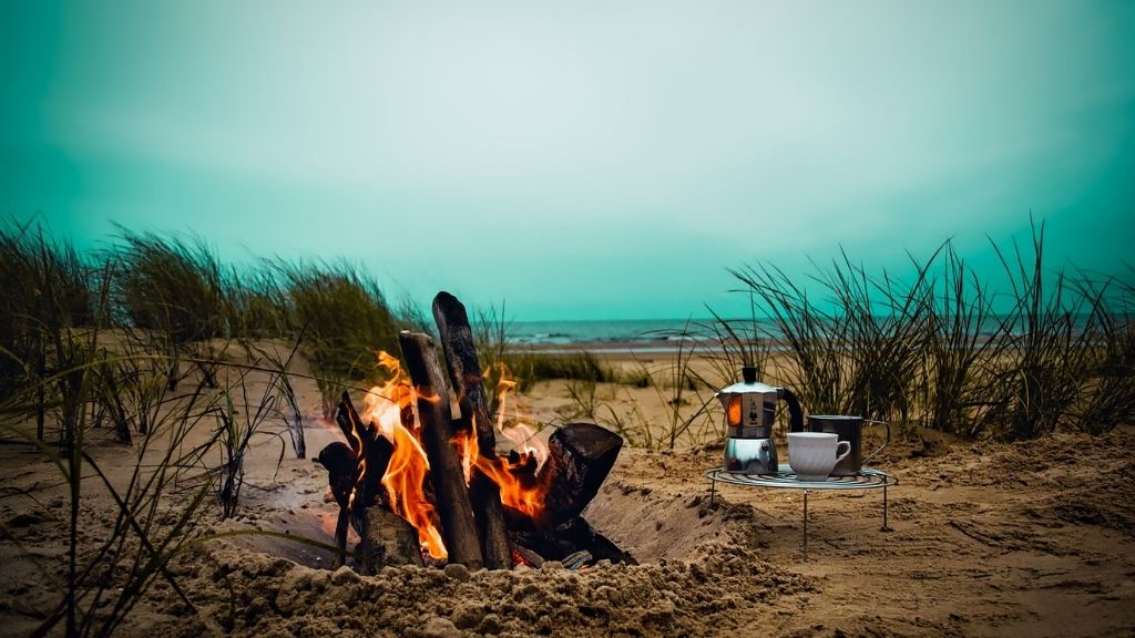 Feu de camp sur la plage, préparation café dans la nature