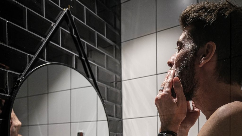 Homme devant son miroir qui applique du baume à barbe bio Bivouak