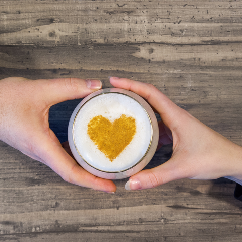 two-hands-holding-cup-with-heart-in-froth