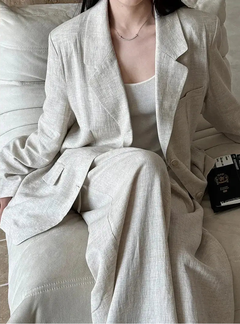 Person wearing a light gray suit sitting on a couch.