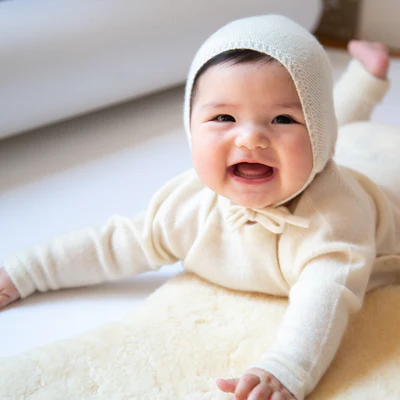 Lachendes Baby mit Mütze zum Zubinden in Weiss von PAPA LOBSTER aus 100% reinem Kaschmir