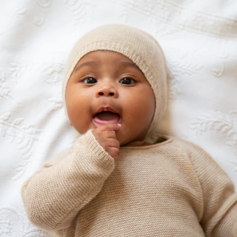 Baby trägt süße gestrickte Baby Mütze in Beige aus reinem Kaschmir