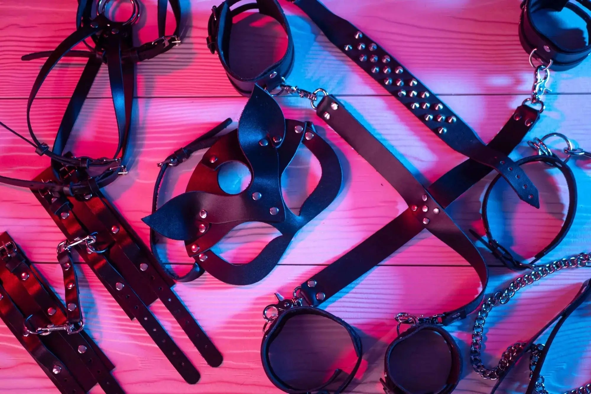 Flutters collection of Bondage toys in pink lighting