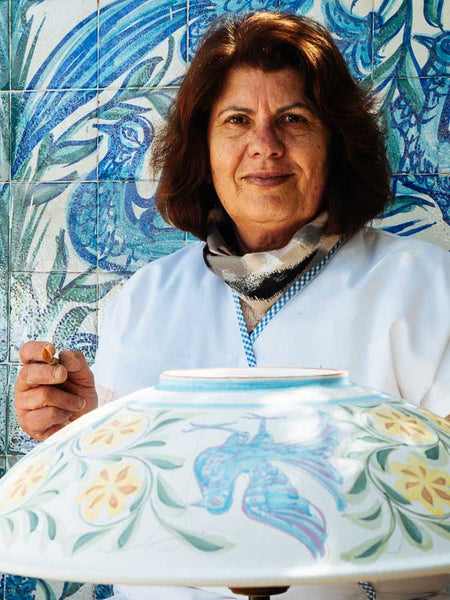 Carmo Santos painting a bowl