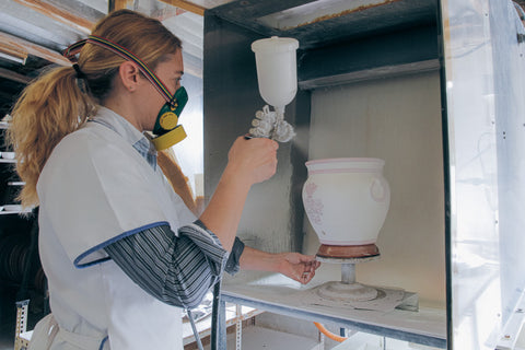 A pot recieving a fine coat of transparent glaze