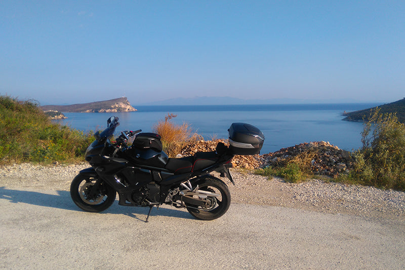czarny motor przy drodze z widokiem na morze