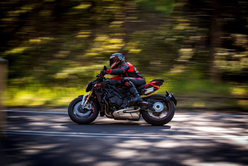 A rider in a red motorcycle suit is riding fast on a red motorcycleThe second thing are shoulders.