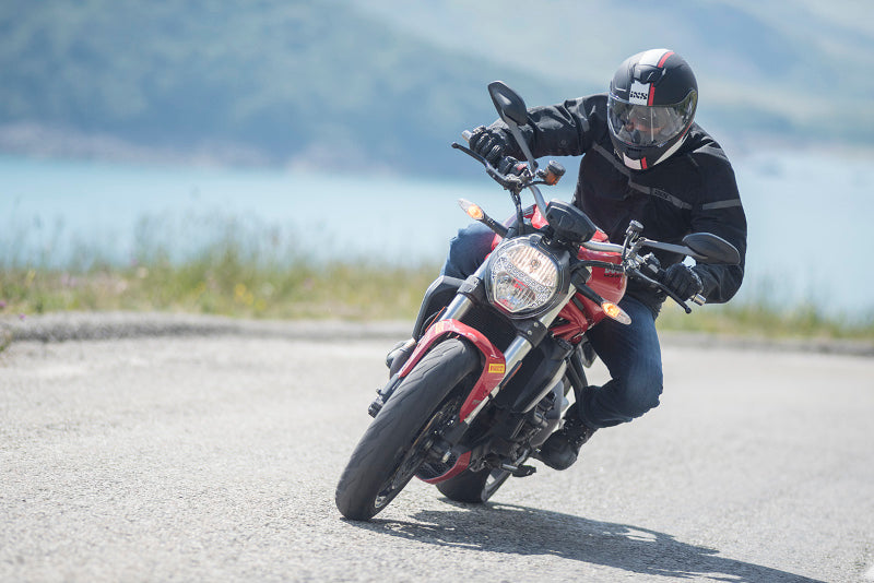 Motocyklista na motocyklu na drodze w tle góry i morze