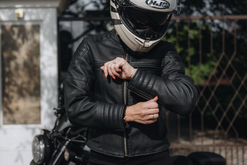 Motocyklistka zapina rękaw kurtki motocyklowej