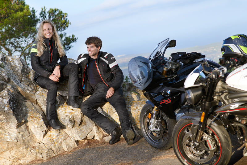 para motocyklistów siedzi na skałkach w kurtkach Held