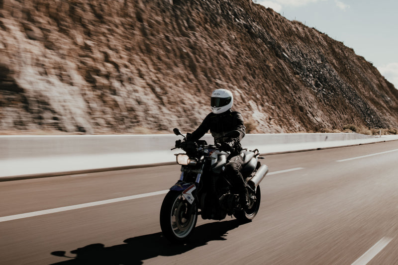 Mężczyzna jedzie na motocyklu drogą szybkiego ruchu