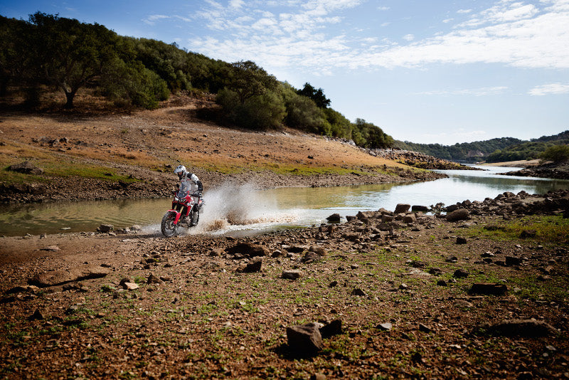 motocyklista przejeżdża przez rzekę w kurtke Carese II na motocykli BMW