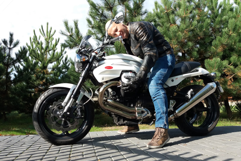 mężczyzna na motocyklu Moto Guzzi w ogrodzie