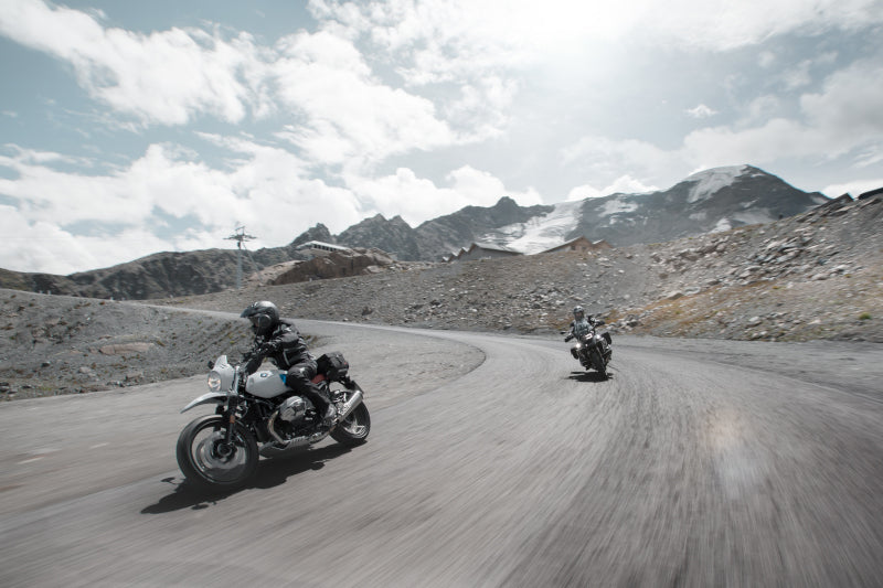 dwóch motocyklistów jedzie po górskiej drodze, mają kufry aluminiowe sw motech