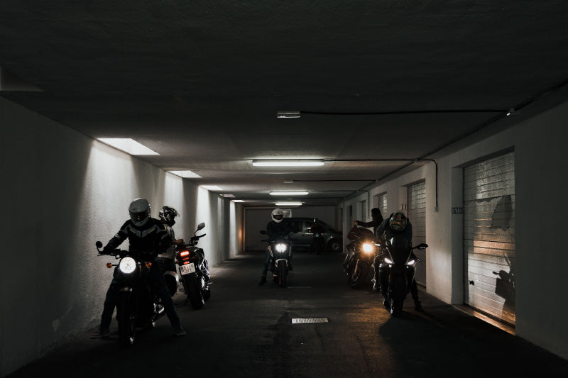 grupa motocyklistów w garażu szykuje się do wyjazdu