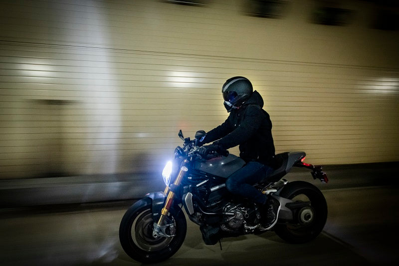 motocyklista jadący nocą przez miasto