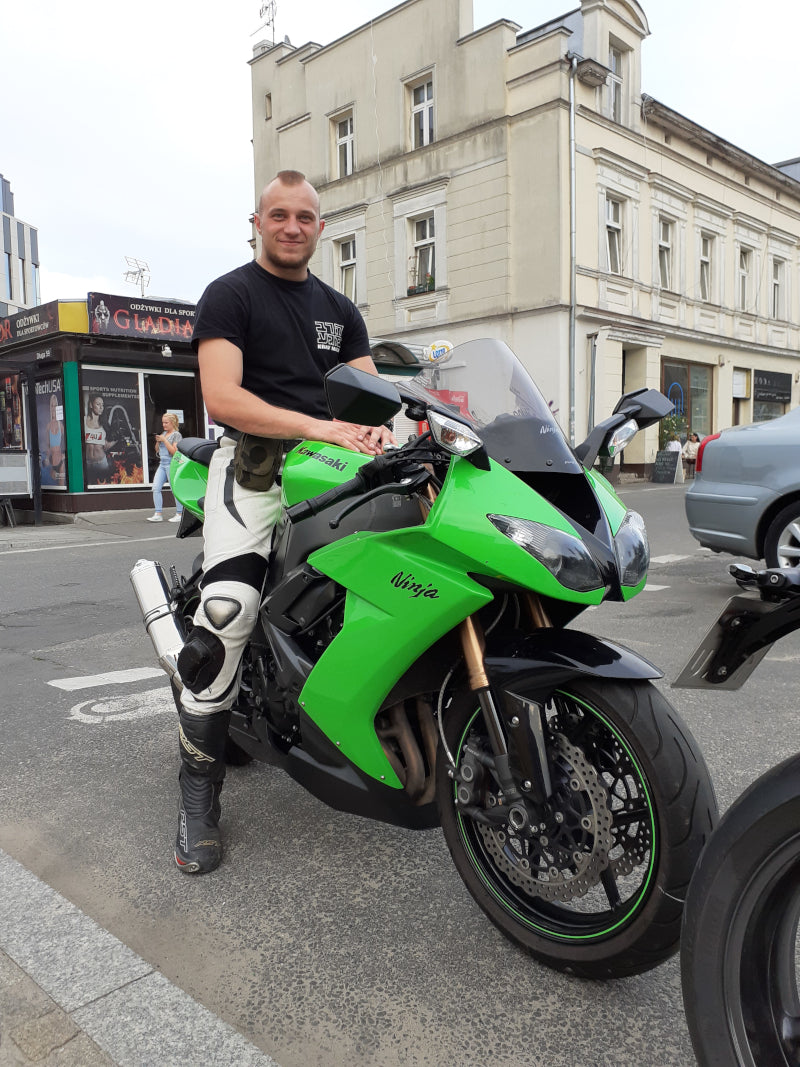 motocykl Kawasaki w kolorze zielonym z motocyklistą w mieście