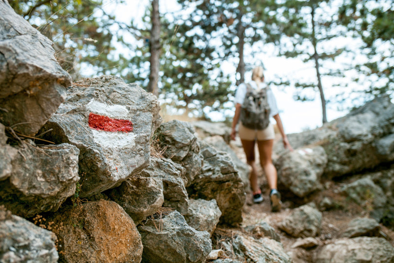 znak czerwonego szlaku turystycznego namalowany na kamieniu