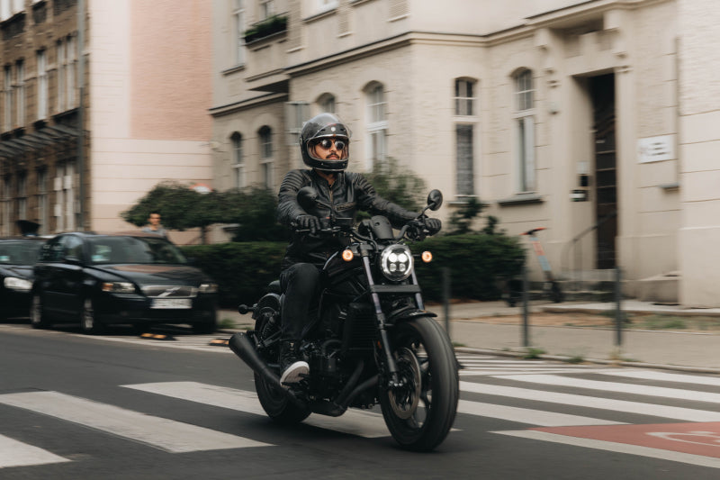 Mężczyzna jedzie na motocyklu w mieście