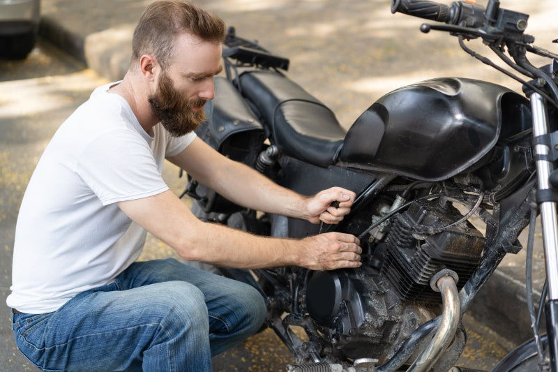 Mężczyzna naprawia uszkodzony motocykl