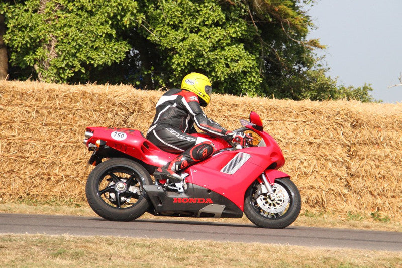 motocyklista na hondzie nr 750 wchodzi w zakręt na torze