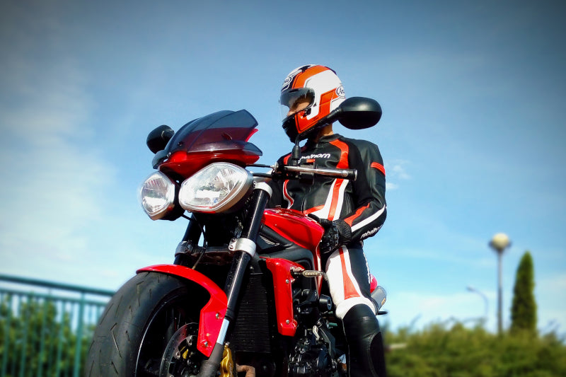 Motocylista w kasku Arai Profile V siedzi na motocyklu