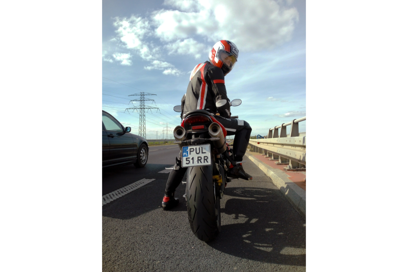 Motocyklista w kasku Arai Profile V siedzi na motocyklu