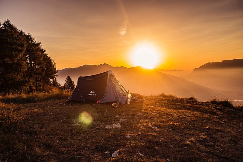 namiot na łące przy zachodzie słońca