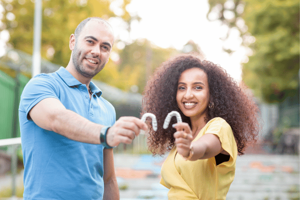 Couple showing their clear aligners