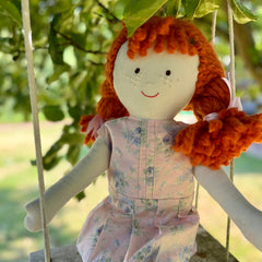 An Emily doll on a swing.