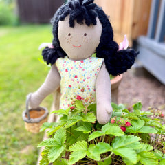 An Olivia doll picking berries.